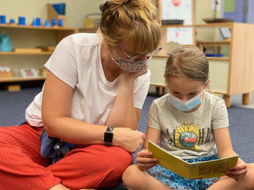 Ms. Leah reads with a student.