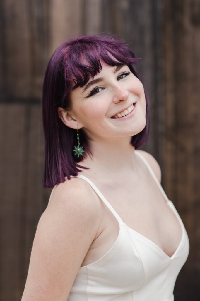 Amelia Tuerk poses in a white dress and star earrings 