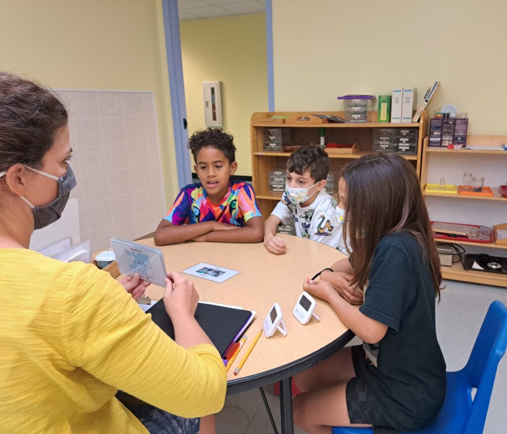 Ms. Jessie tutors three kids with flash cards 