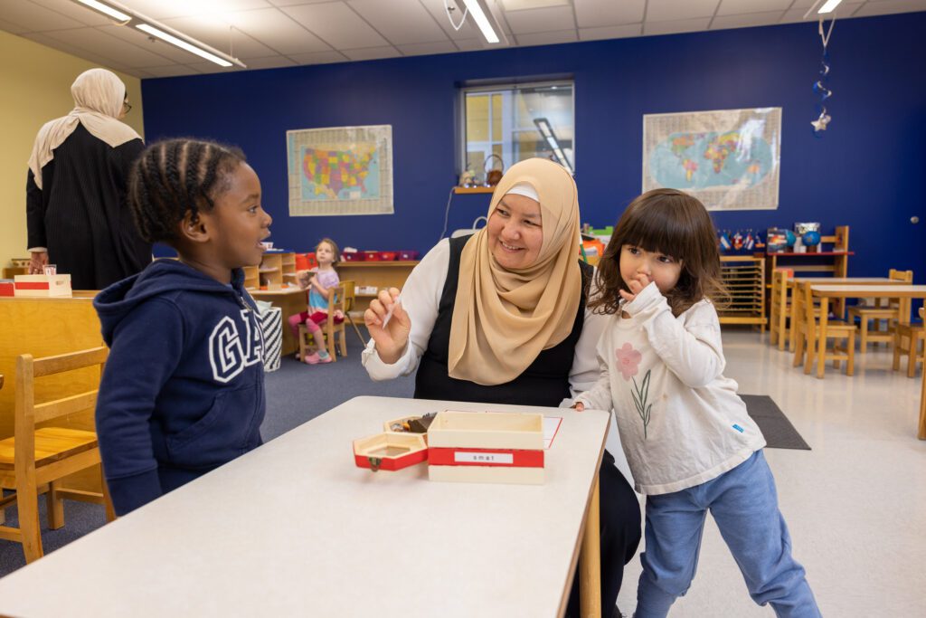 Two students at table with teacher